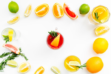 Concept of alcoholic cocktail with fruits. Glass with beverage near oranges, grapefruit, lime and rosemary on white background top view pattern