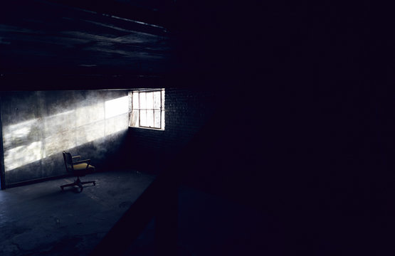 Sunlight shining on empty chair through basement window