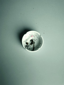 Used cigarette with lipstick mark in ashtray