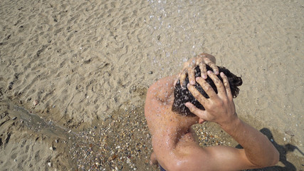 Man taking shower on beach