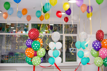 Colorful balloons hang under the white ceiling.