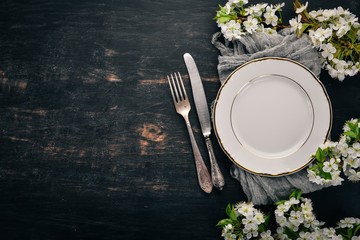 Serving table in spring style. Fresh flowers. Top view. On a wooden background. Copy space.