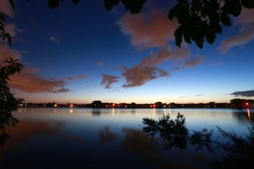 Fototapeta na wymiar Lakeside View Overlooking Residential Neighborhood with Lights Illuminated in Deerfield Beach, Florida After Dusk