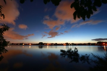 Fototapeta na wymiar Lakeside View Overlooking Residential Neighborhood with Lights Illuminated in Deerfield Beach, Florida After Dusk
