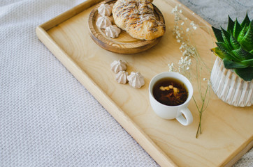 Breakfast in bed, fragrant tea and croissants for breakfast