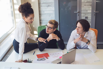 Dreams mean to work hard! Group of young coworkers working at the table in order to achieve their...