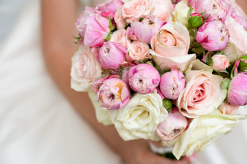 beautiful delicate Bridal bouquet of white, pink roses and flowers in hands of bride