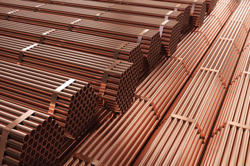 Obraz na płótnie Canvas Stack of copper pipes in warehouse. Rolled metal products.