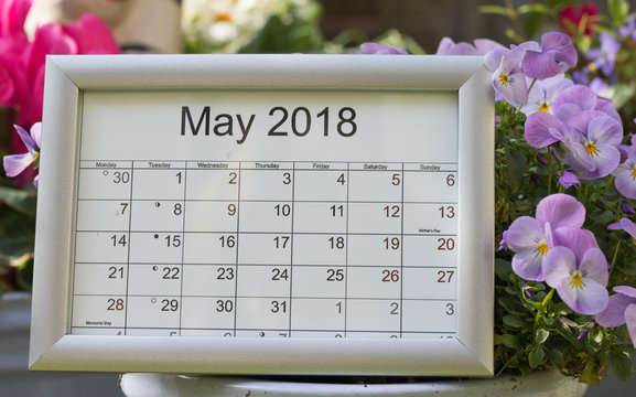 May 2018: calendar of the month with lunar days among spring flowers. Mother`s Day & Memorial Day are celebration.