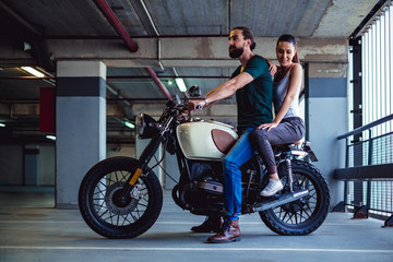 Fototapeta na wymiar Couple sitting on a motorcycle in a garage