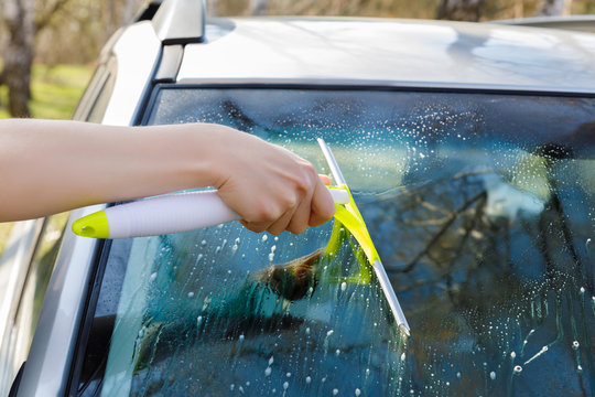 Washes and cleans the glass of a car .