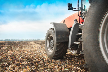 Modern red tractor in the field close-up.