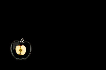 sliced apple in a glass bowl on a black background