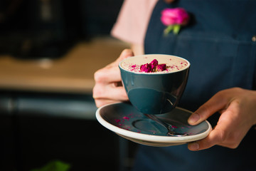 Cup of raf rose coffee in barista hands