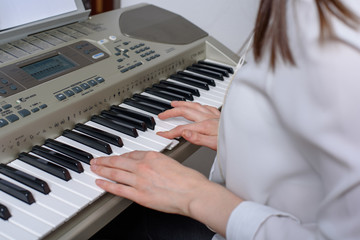 Close-up of female hands with synthesizer