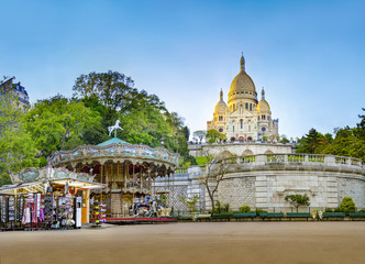 Panorama of the famous basilica of Sacre-Coeur in Montmartre, Paris at sunset with carousel horse...