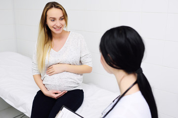 young pretty pregnant woman in a clinic at a female consultation with a gynecologist-obstetrician doctor