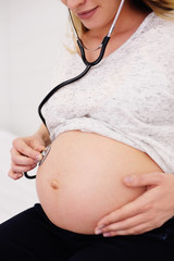cute young pregnant woman on plans examining in a female consultation. Motherhood, happiness,...