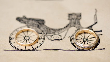 Fototapeta na wymiar Wedding rings on a paper with retro bike illustration.