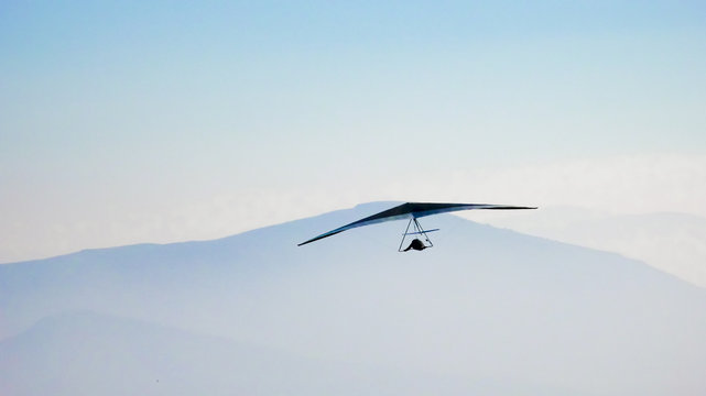 Hang glider flying in the mountains
