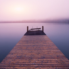 Empty footbridge with a bench on a lake Altausseer at sunrise