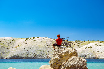 Mountain biker looking at mountains and beach