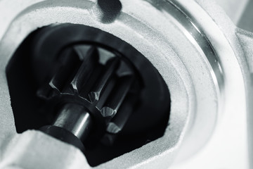 Background image of auto parts with rotor close-up. Big black pinion in metal part. Gear parts...