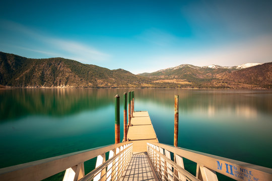 Long exposure of a dock at a marina overlooking Lake Chelan and the foothills