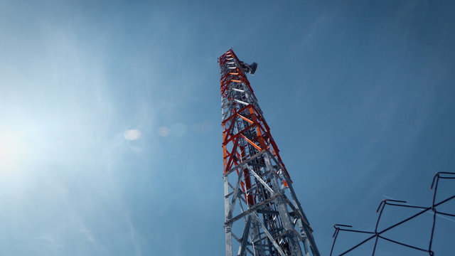 Communication Tower against blue sky and sun flares