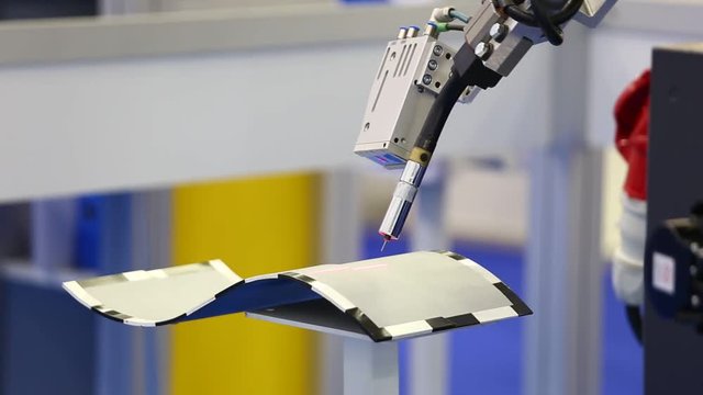 A robotic arm with laser cutter. Automatic robot in a modern factory in operation. 