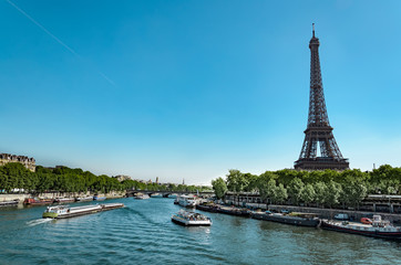 Fototapeta na wymiar Panoramic view of living barge on the Seine in Paris with Eiffel tower and tourist and cargo boats, France