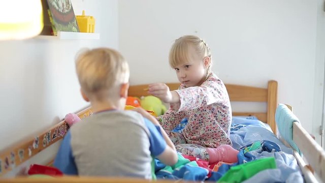 Little children have a fun in the bed.