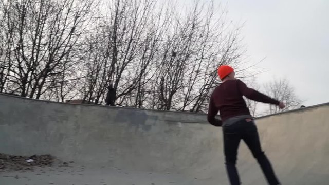 Teenager skateboarding at outdoor skate park. In the pool