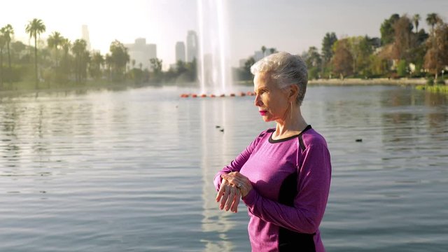 71 year old woman checks her step counter to see how her workout is going.