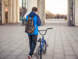 young teenager in the city with bicycle with backpack