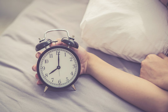 Closeup Asian Young Woman Turn Off Alarm Clock In Good Morning, Wake Up For Sleep With  Girl Holding Alarm Clock, Time And Lifestyle Concept.