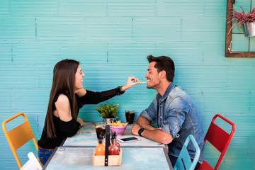 Happy young couple seating in a restaurant © DavidPrado