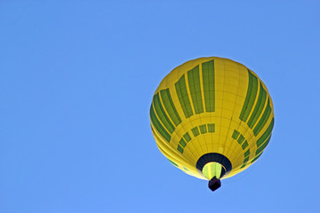 Yellow air balloon on the blue sky background. View from bottom