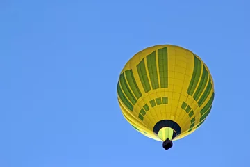 Fotobehang Luchtsport Gele luchtballon op de blauwe hemelachtergrond. Uitzicht vanaf de onderkant