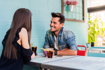 Happy young couple seating in a restaurant