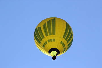 Yellow air balloon on the blue sky background. View from bottom
