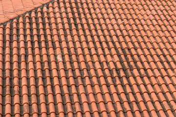 Top view of old and weathered clay tile roof, pattern of orange tiles