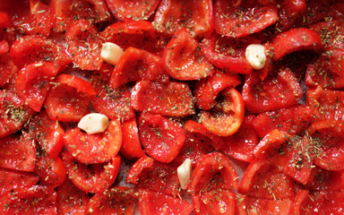 Tomatoes lie on a baking sheet, ready to bake. Sun-dried tomatoes with garlic.