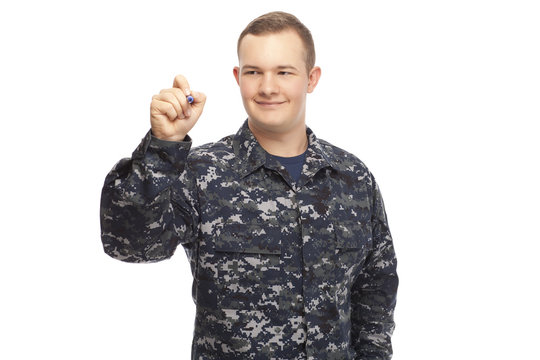 Young man in navy uniform writing on screen