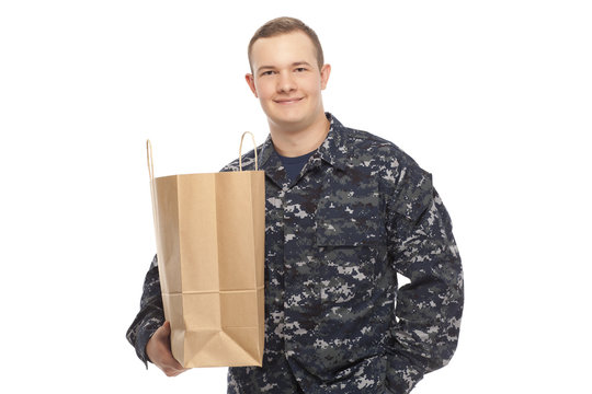 Young Man In Navy Uniform With Grocery Store Paper Bag