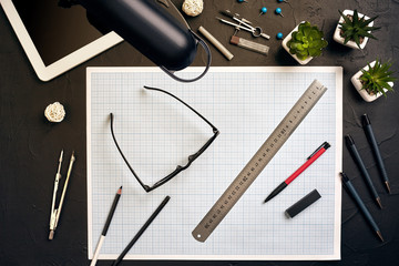 Top view of the builder's workplace, ruler, paper for drawings, compasses, glasses, tablet
