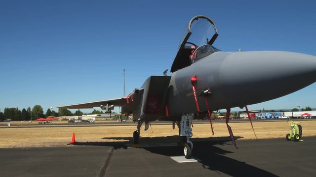 A military jet on display at an air show, cockpit open