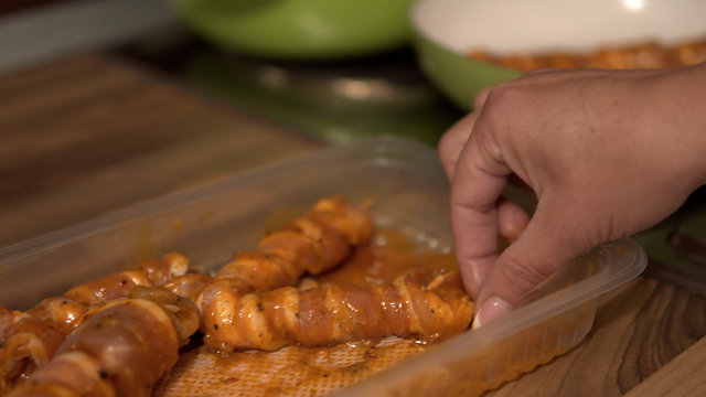 Juicy roasted chicken skewers, made of white meat and bacon, being turned in frying pan