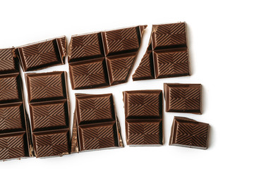 Broken chocolate bar, white background top view
