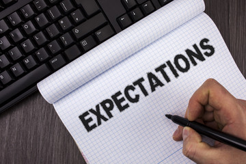 Conceptual hand writing showing Expectations. Business photo text Huge sales in equity market assumptions by an expert analyst written by Marker in Hand on Notebook on wooden background Keyboard